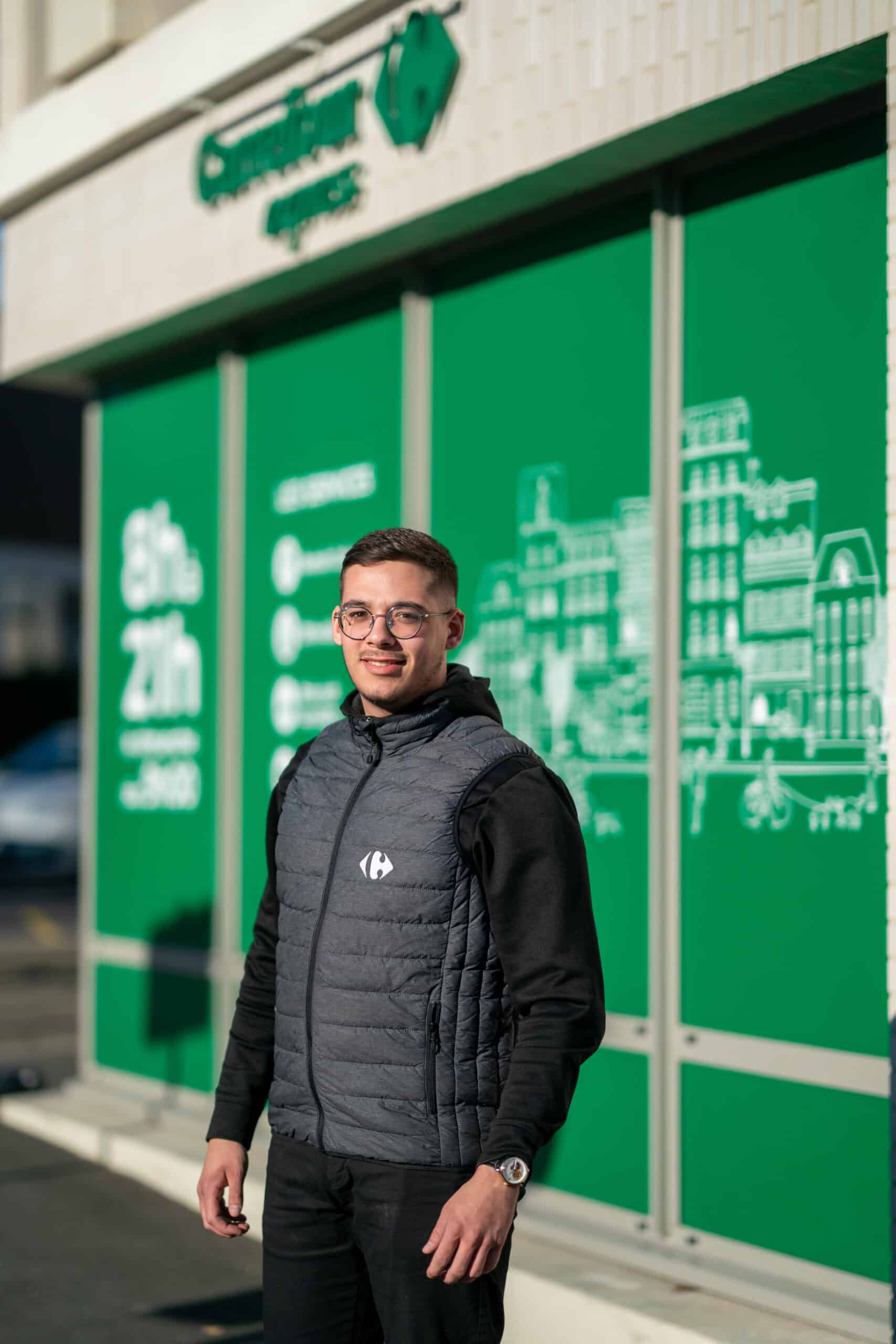 Collaborateur Carrefour devant un magasin Carrefour Express