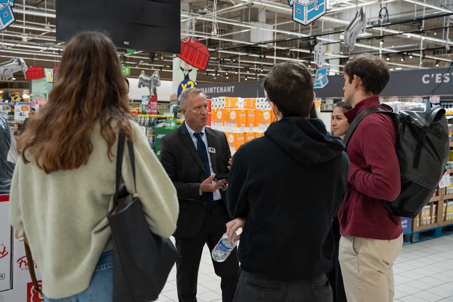 Groupe de Graduates écoutant un Directeur d'hypermarché Carrefour