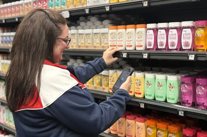 Collaboratrice Carrefour au sein d'un rayon montrant comment la solution vusion (étiquette électronique, rails connectés, géolocalisation...) lui permet de gagner du temps dans sa préparation de commandes e-commerce